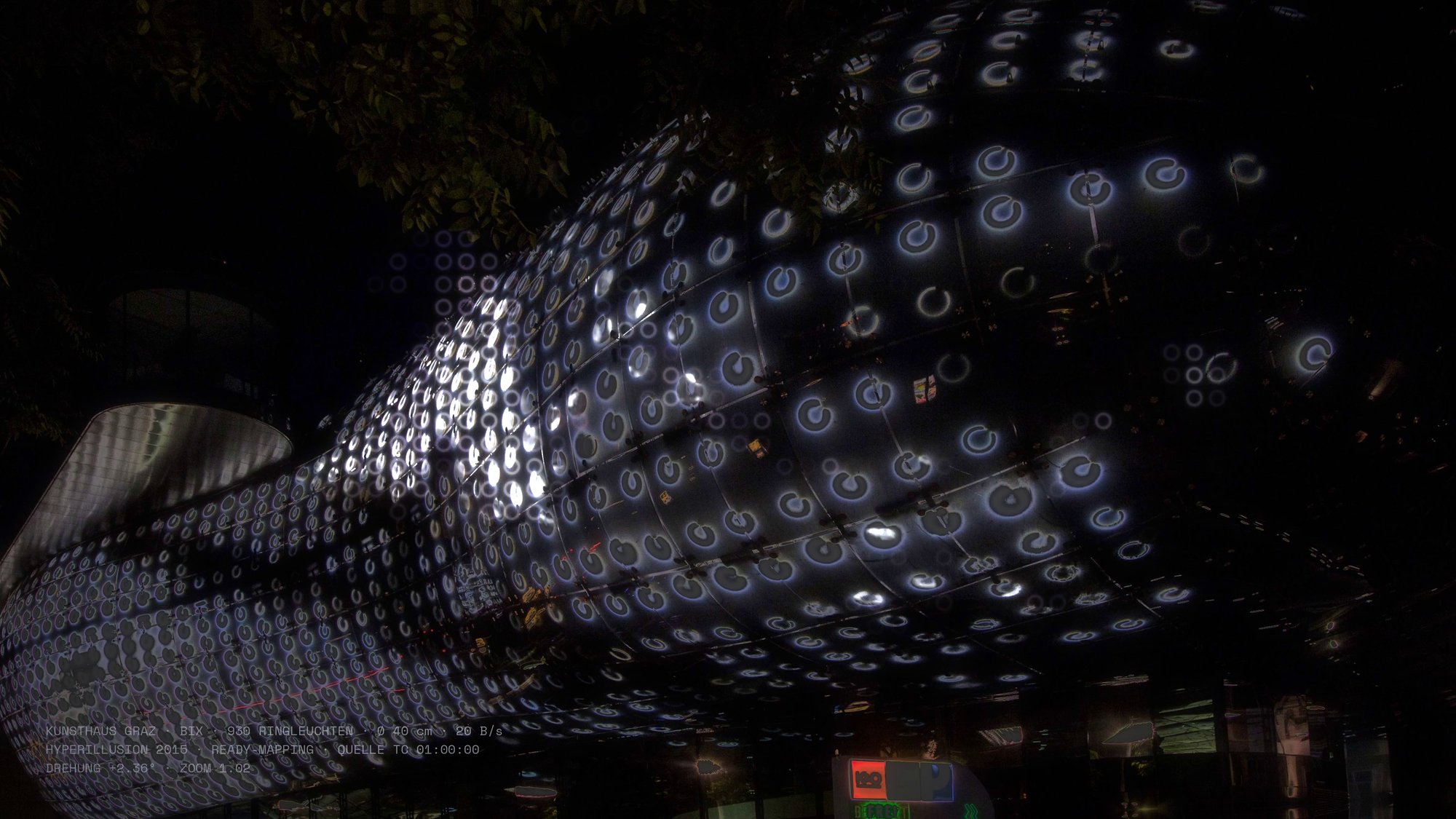 Still aus Kapitel I KINDLY ALIEN: die BIX-Fassade des Kunsthauses Graz, deren 930 Ringleuchten das Hyperillusion-Video von 2015 als Ready-Mapping wiedergeben